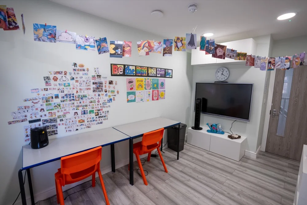 Room with desks, TV, and decorations.