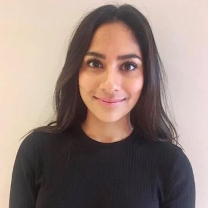 Woman with dark hair wearing a black top smiling at the camera.