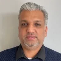 Close-up portrait of a man with graying hair and a beard.