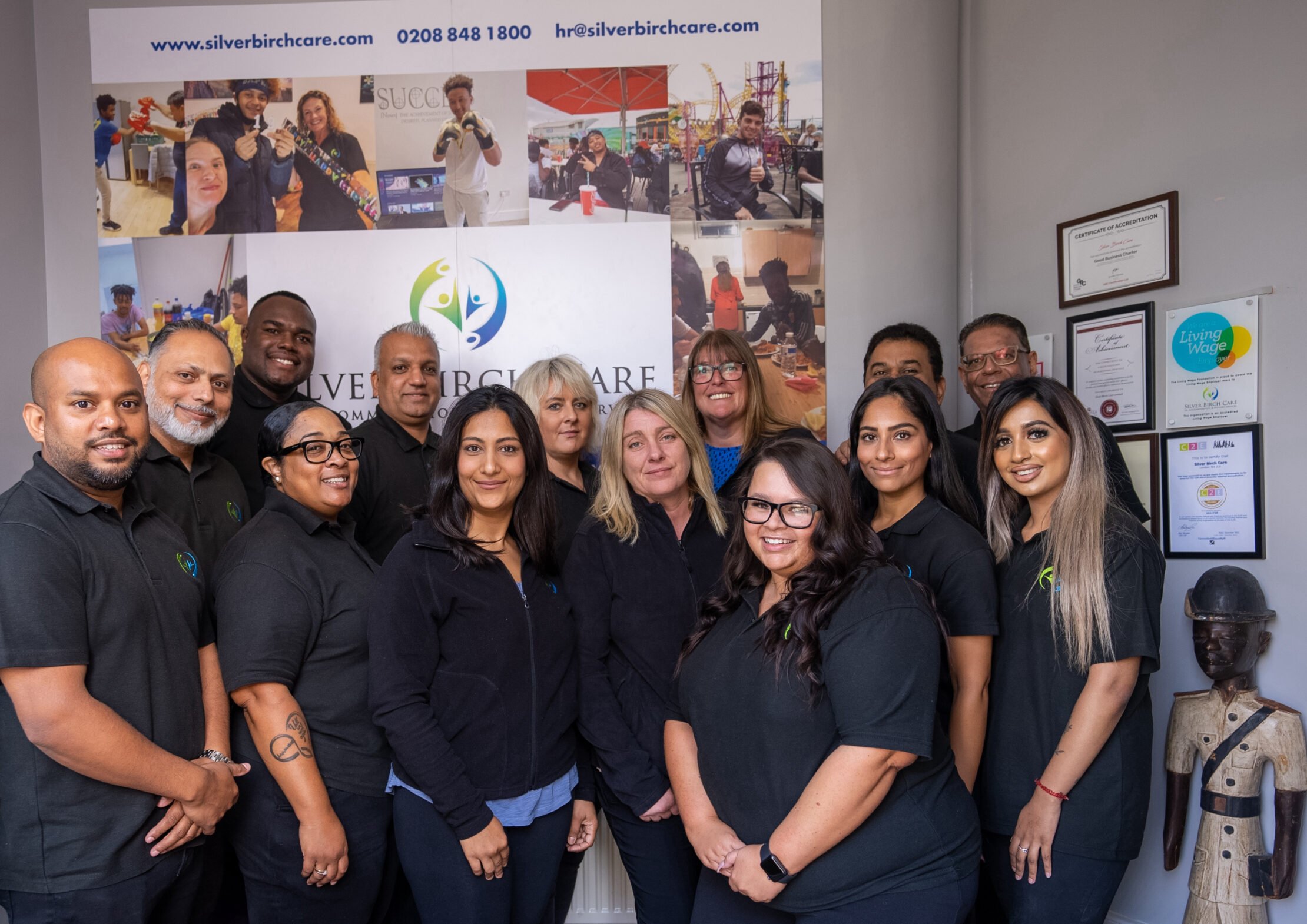 Group of people posing for a photo in black shirts.