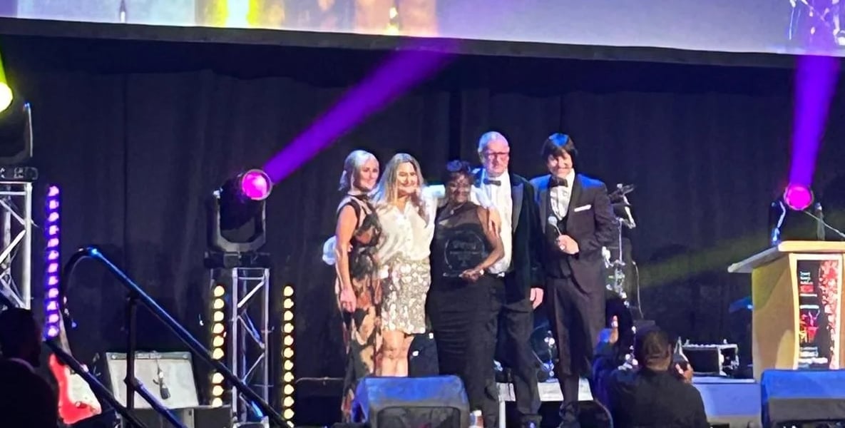 People on stage with awards, at a gala.